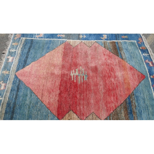 1026 - An oriental deep pile woven wool carpet with geometric design and blue border, 200 x 150cm