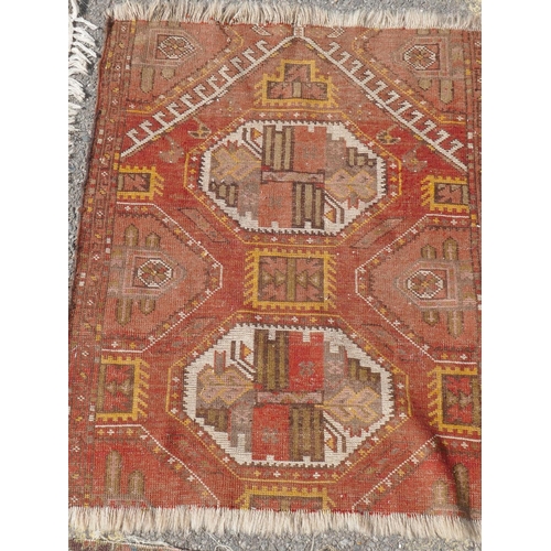 1029 - A small Persian rug, with medallion design on a terracotta field, another similar, a cut down rug an... 