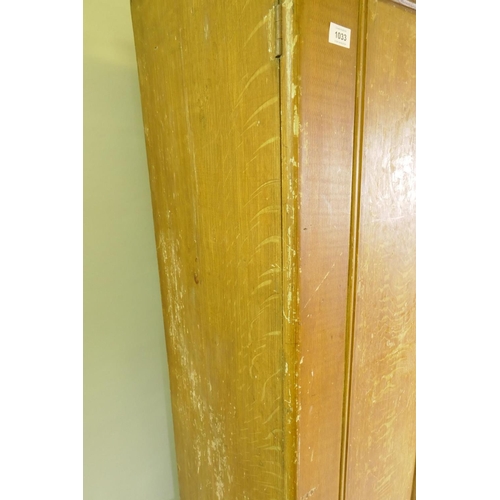 1033 - A Victorian grain painted pine wardrobe, with two doors over a single drawer, raised on a plinth bas... 