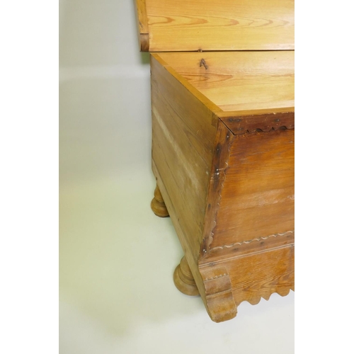 1038 - A C19th Continental pine dower chest with lift up top and decorative shaped apron, raised on turned ... 