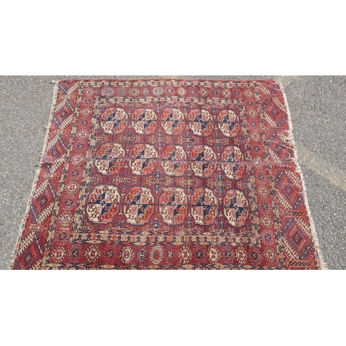 1041 - An oriental hand woven rug, with repeating geometric pattern on a terracotta field, repaird, 127 x 1... 