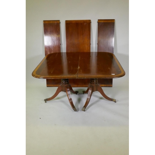 1049 - A C19th mahogany twin pillar dining table with satinwood banded top, raised on twisted columns and t... 