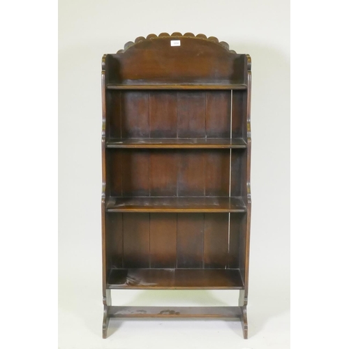 1054 - A mid century cottage oak open bookcase, with carved and shaped back, 62 x 127 x 28cm