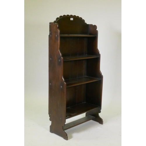 1054 - A mid century cottage oak open bookcase, with carved and shaped back, 62 x 127 x 28cm