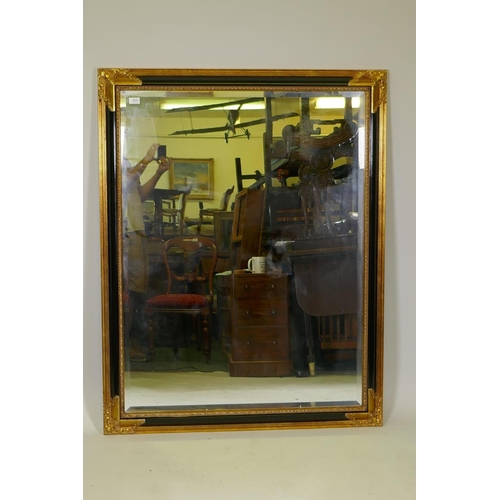 1070 - A large gilt and ebonised over mantel mirror, 104 x 132cm