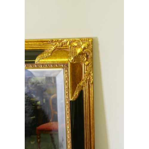 1070 - A large gilt and ebonised over mantel mirror, 104 x 132cm