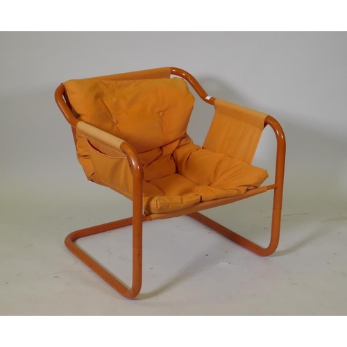 1073 - A vintage Danish tubular steel easy chair with buttoned cushion seat