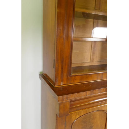 1083 - A Victorian mahogany bookcase with two arched glazed doors over two frieze drawers and cupboards, ra... 