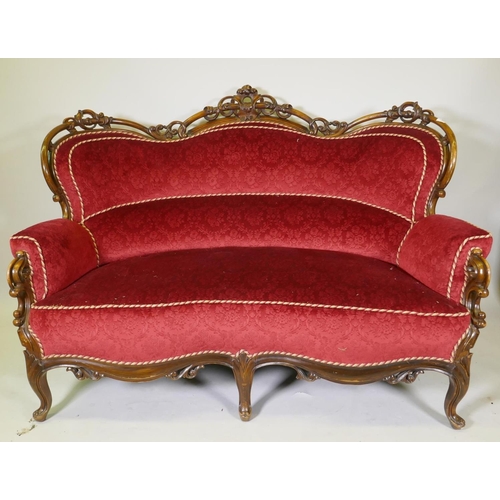 1092 - A Victorian showframe walnut two seater settee, with carved and pierced back scroll arms and shaped ... 