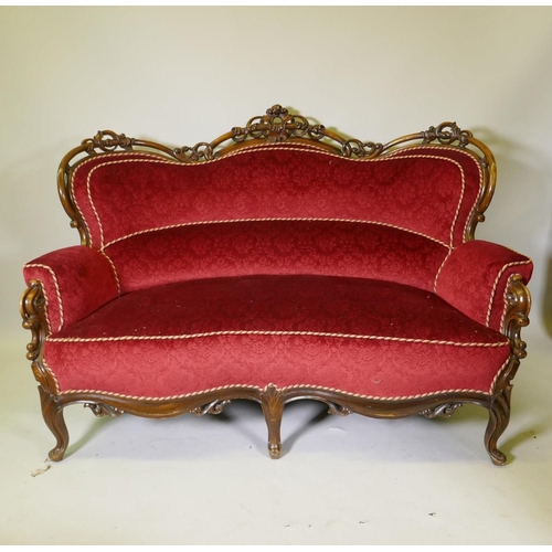 1092 - A Victorian showframe walnut two seater settee, with carved and pierced back scroll arms and shaped ... 