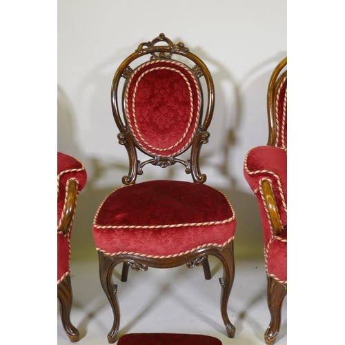 1093 - A pair of Victorian show frame walnut arm chairs, with carved and pierced backs, raised on shaped su... 