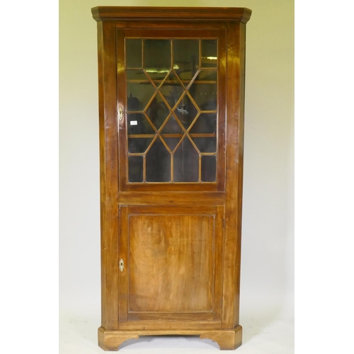 1100 - A George III mahogany standing corner cabinet, with astragal glazed door over cupboard, raised on a ... 