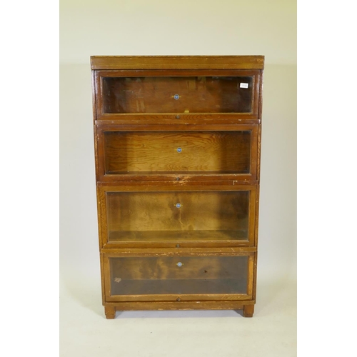 1118 - A Globe Wernicke four section oak bookcase, raised on a base section with block feet, 86 x 29 x 143x... 