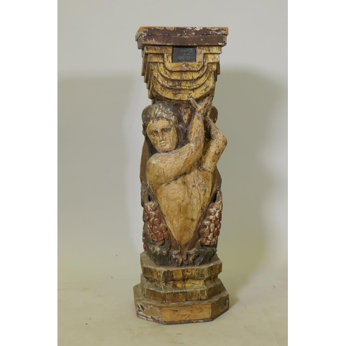 1136 - A carved and polychrome painted wood pedestal/stand in the form of a putto holding aloft a stand wit... 