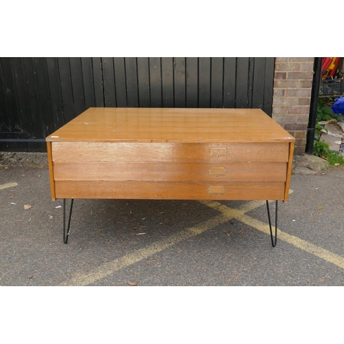 1142 - A mid century plan chest of three long drawers, raised on pin supports, 131 x 100 x 68cm