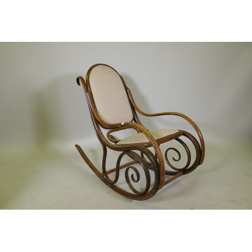 1143 - An early C20th Thonet style bentwood rocking chair with caned seat and back