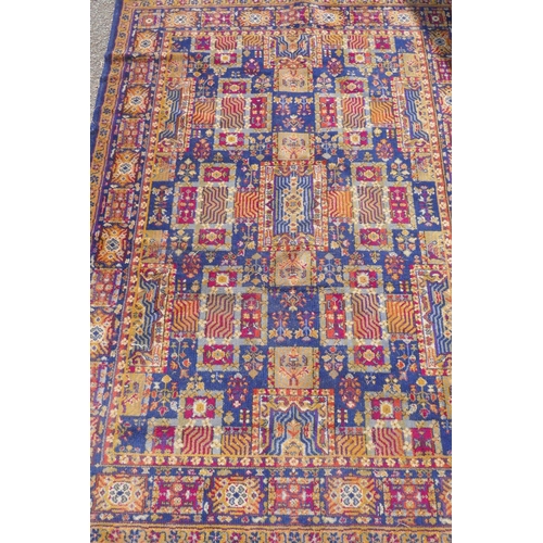 1146 - A vintage oriental wool carpet with all over geometric designs on a blue field, 140 x 197cm