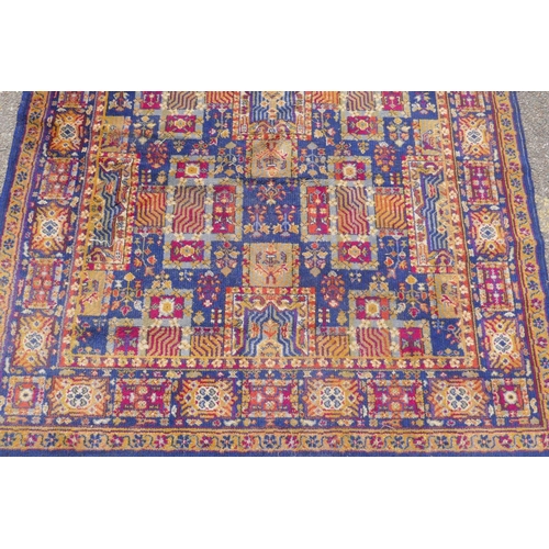 1146 - A vintage oriental wool carpet with all over geometric designs on a blue field, 140 x 197cm