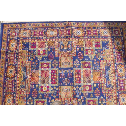 1146 - A vintage oriental wool carpet with all over geometric designs on a blue field, 140 x 197cm