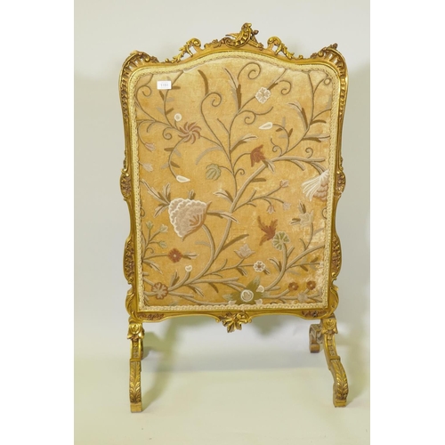 1151 - A carved giltwood fire screen with inset embroidered panel, 70cm wide, 108cm high