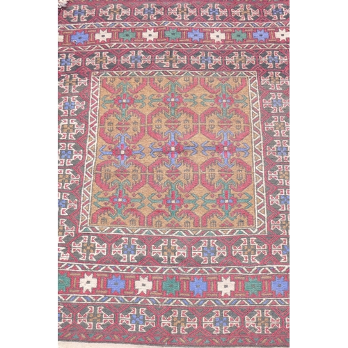 1153 - A Middle Eastern wool rug with red borders around a gold coloured central medallion pattern, 96 x 12... 