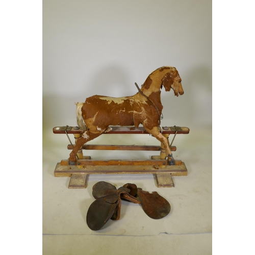 1158 - An antique rocking horse, stuffed straw and pony hide covers with leather saddle and painted pine ba... 