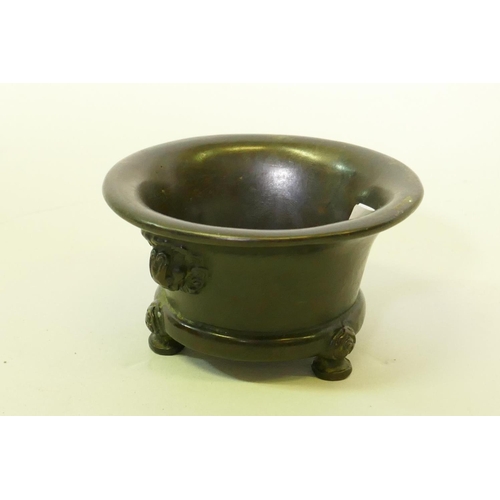 118 - A Chinese bronze censer with black patination and mask decoration, raised on tripod supports with ca... 