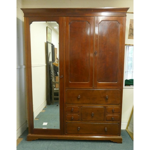 1195 - A Victorian mahogany wardrobe in two sections with single mirrored door, two cupboards over a fall f... 