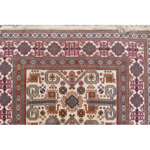 1224 - Eastern wool carpet with geometric designs on an ivory field, 118 x 166cm