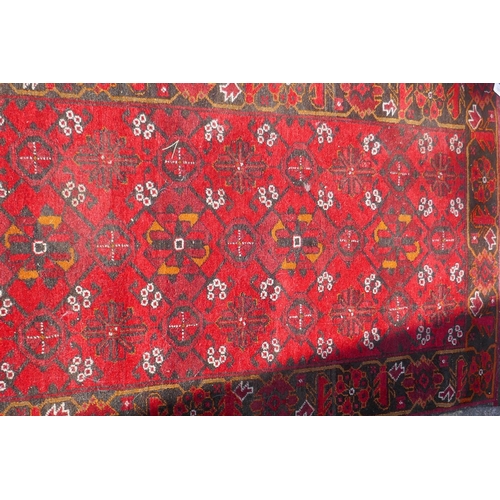 1227 - A Persian wool runner with geometric designs on a red field and black borders, 85 x 288cm