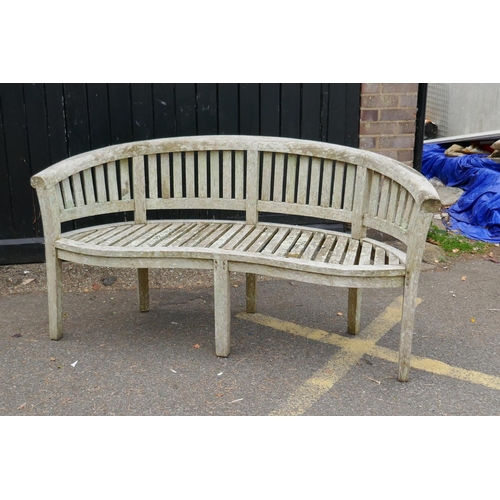 1230 - A weathered bow shaped garden bench, 160cm long