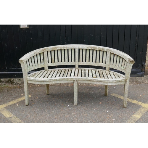 1230 - A weathered bow shaped garden bench, 160cm long