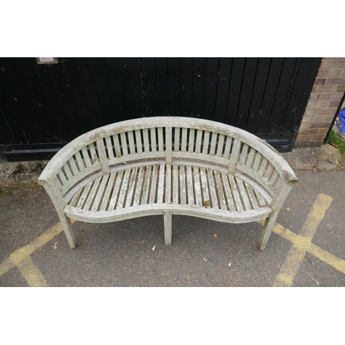 1230 - A weathered bow shaped garden bench, 160cm long