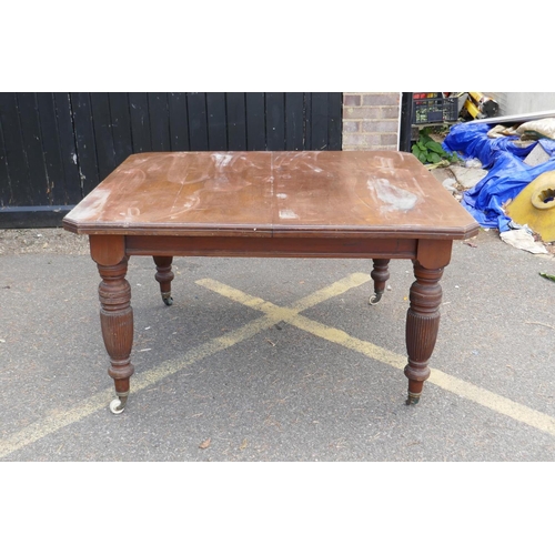 1232 - Victorian walnut windout dining table, with cut corner top, raised on reeded supports, AF, lacks lea... 