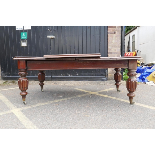 1233 - Victorian mahogany draw leaf dining table raised on carved bulbous supports with brass castors, with... 