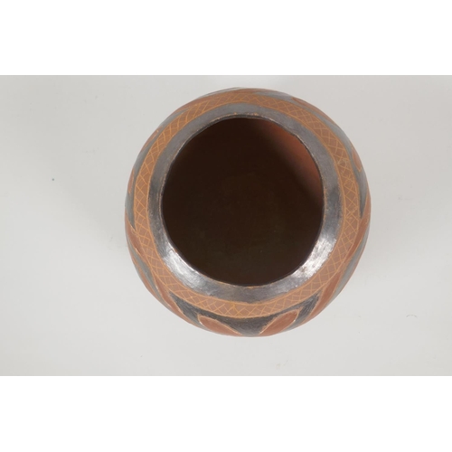 124 - A South American terracotta pot with lustre glazed details, 20cm diameter