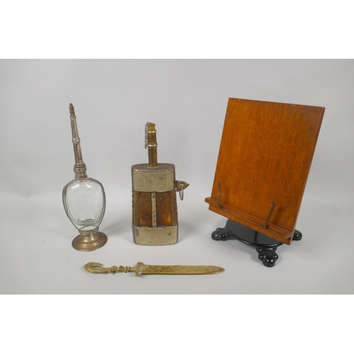 134 - An eastern brass mounted horn powder flask, a white metal mounted water sprinkler, a brass paper kni... 