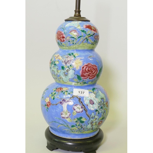 137 - A Chinese triple gourd ceramic vase with floral decoration, converted to a lamp and mounted on a woo... 