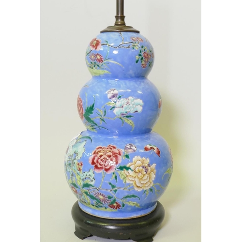 137 - A Chinese triple gourd ceramic vase with floral decoration, converted to a lamp and mounted on a woo... 