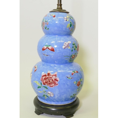 137 - A Chinese triple gourd ceramic vase with floral decoration, converted to a lamp and mounted on a woo... 