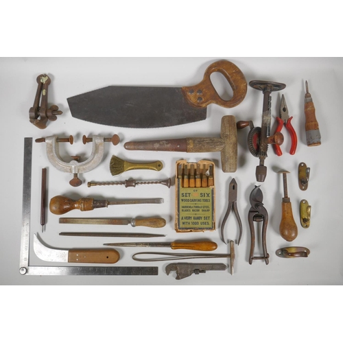 144 - A collection of vintage hand tools including floorboard saw, clamps, wood carving tools, and drills ... 