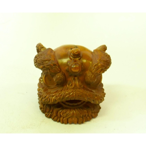 161 - A carved boxwood netsuke in the form of a foo lion, 5cm high, and a wood ball carved with a phoenix ... 