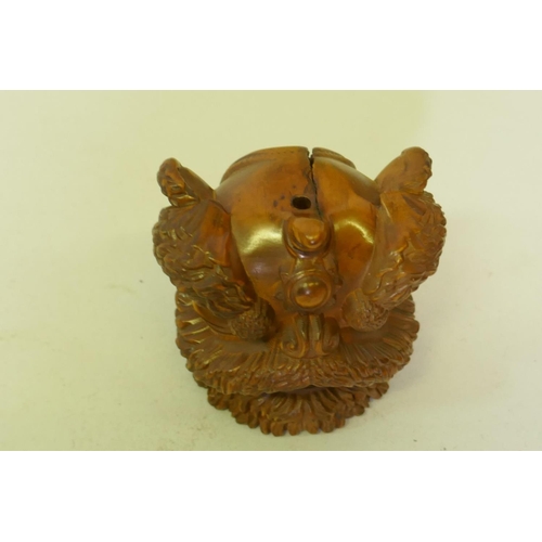 161 - A carved boxwood netsuke in the form of a foo lion, 5cm high, and a wood ball carved with a phoenix ... 