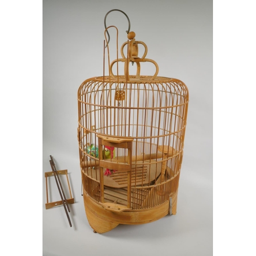 170 - An oriental bamboo bird cage, with famille verte porcelain bird feeder, 68cm high, 36cm diamete... 