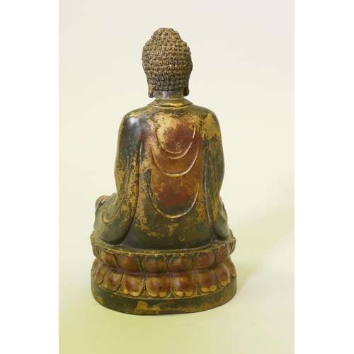 171 - A painted and gilt bronze figure of Buddha, seated upon a lotus throne, 22cm high