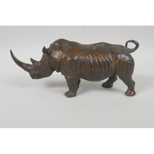 176 - A filled bronze figure of a rhinoceros with the remnants of gilt patina, 24cm long