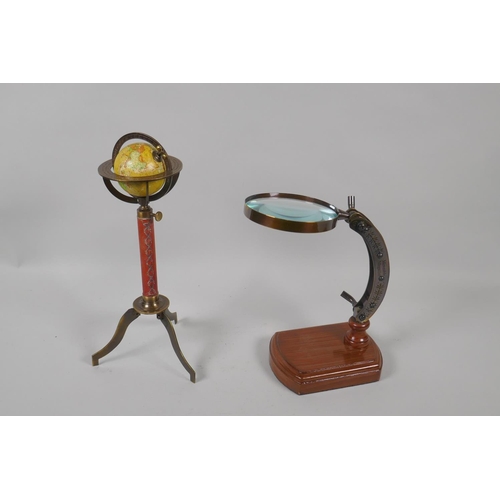 177 - A miniature desk top leather and brass terrestrial globe, and a desk top magnifying glass, 28cm high