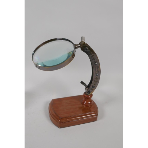 177 - A miniature desk top leather and brass terrestrial globe, and a desk top magnifying glass, 28cm high