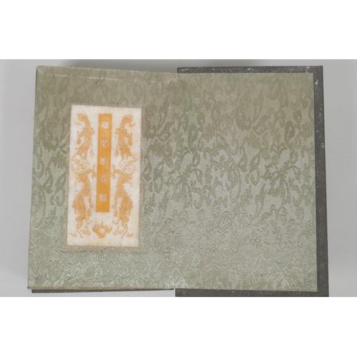 181 - A Chinese wood and silk bound book with white jade tablet pages bearing chased and gilt inscriptions... 