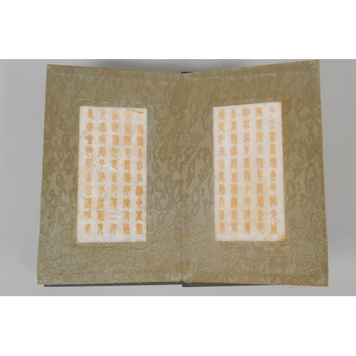 181 - A Chinese wood and silk bound book with white jade tablet pages bearing chased and gilt inscriptions... 